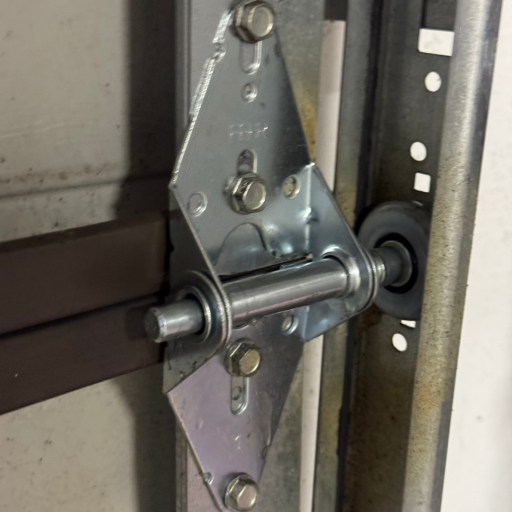 Garage door roller and hinge bracket during replacement service in Ocala FL