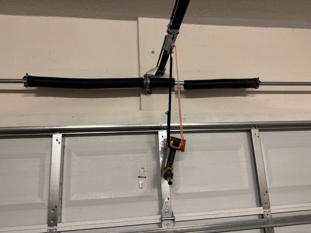 Broken torsion spring with visible gap above residential garage door in Ocala home
